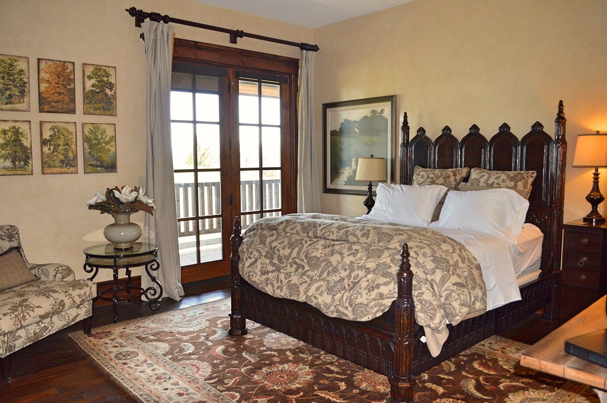 Queen bed with lamp and stuffed chair