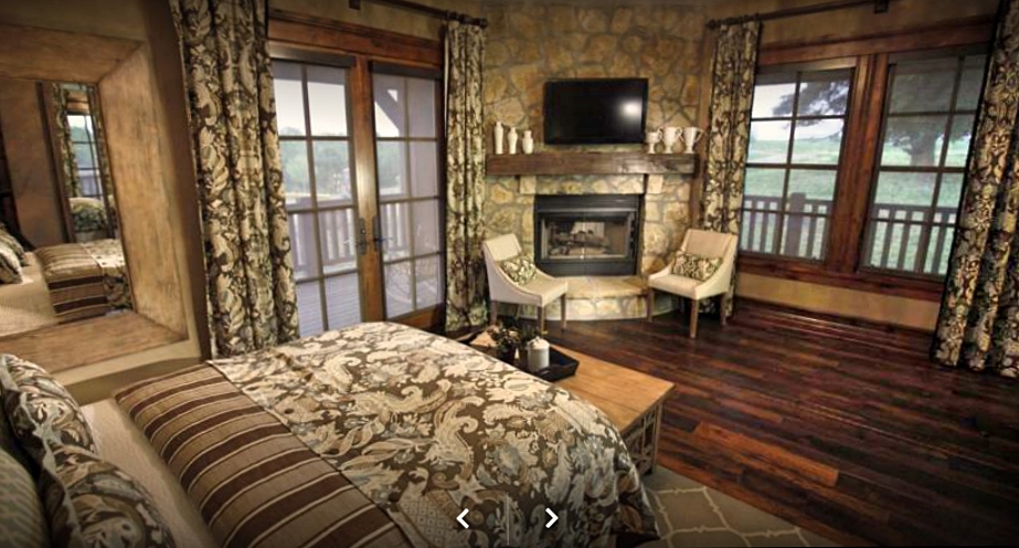 Lake room angle showing bed, TV, fireplace and two chairs